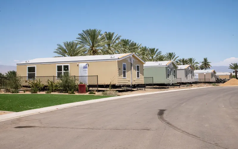 Row of well-kept manufactured homes with green lawns in a tidy community